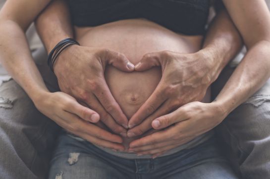 Closeup of heart shape of a couple hands together on the pregnant woman's belly - ©pololia - stock.adobe.com